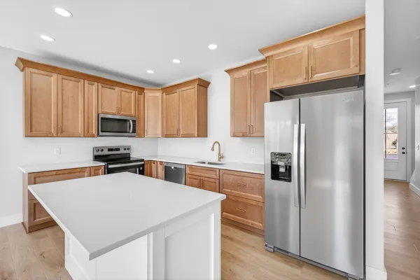 a kitchen with cabinets stainless steel appliances and a counter space