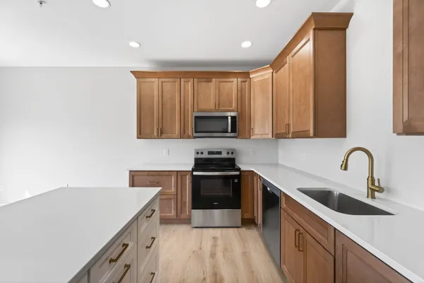 a kitchen with granite countertop white cabinets and stainless steel appliances