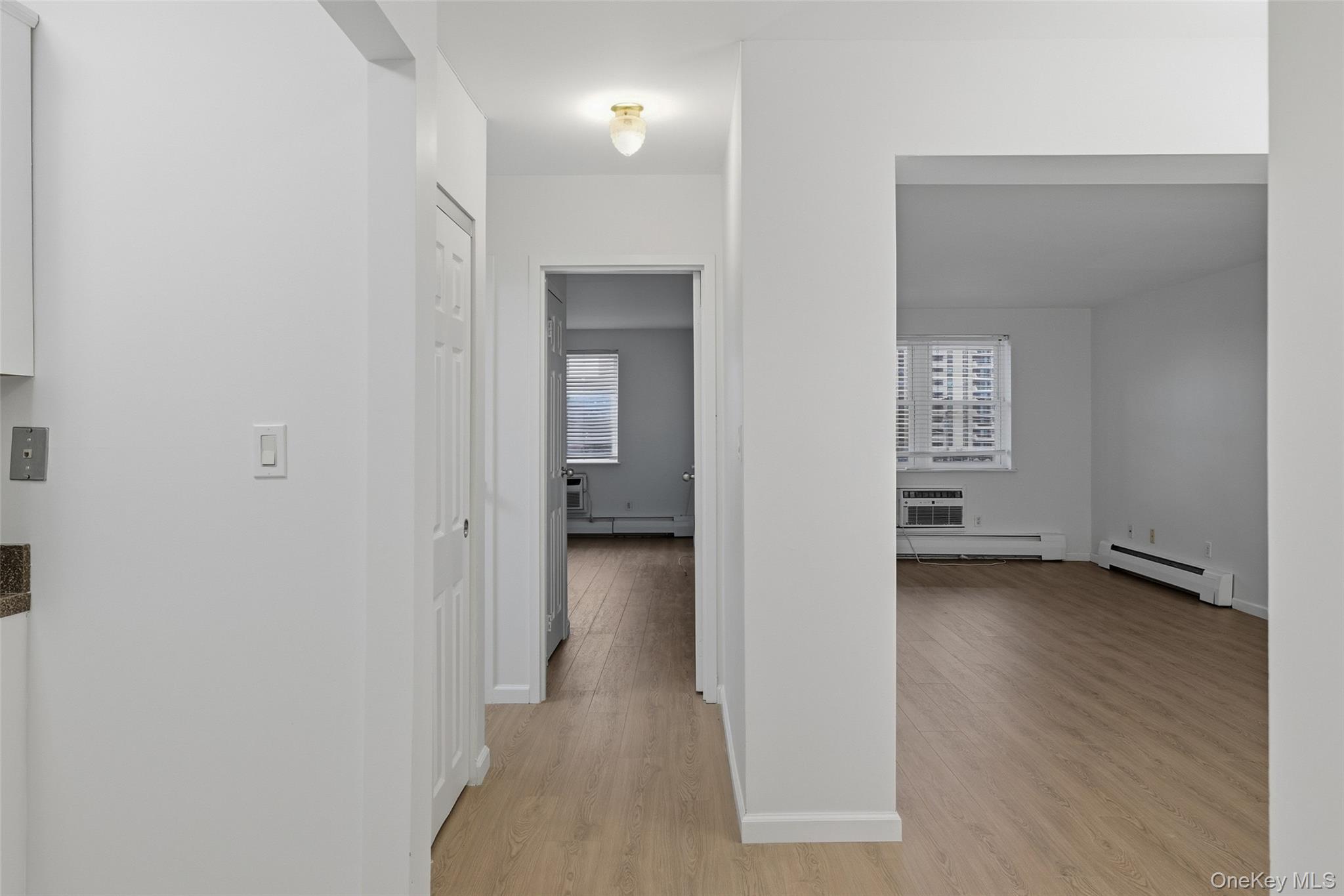 55 Monroe Boulevard, Unit 2L Long Beach, NY 11561 - Photo 12 of 25 a view of a hallway with wooden floor and a bathroom
