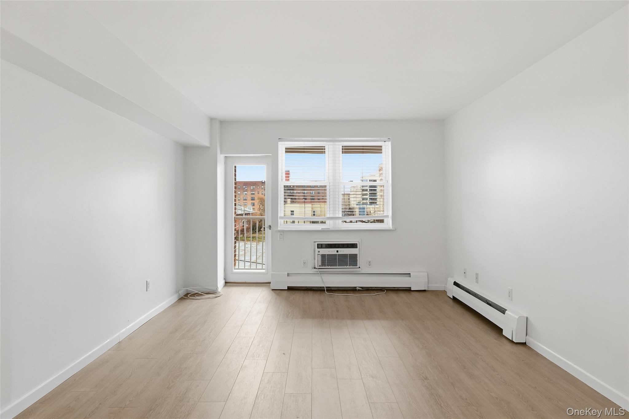 55 Monroe Boulevard, Unit 2L Long Beach, NY 11561 - Photo 14 of 25 an empty room with wooden floor and windows