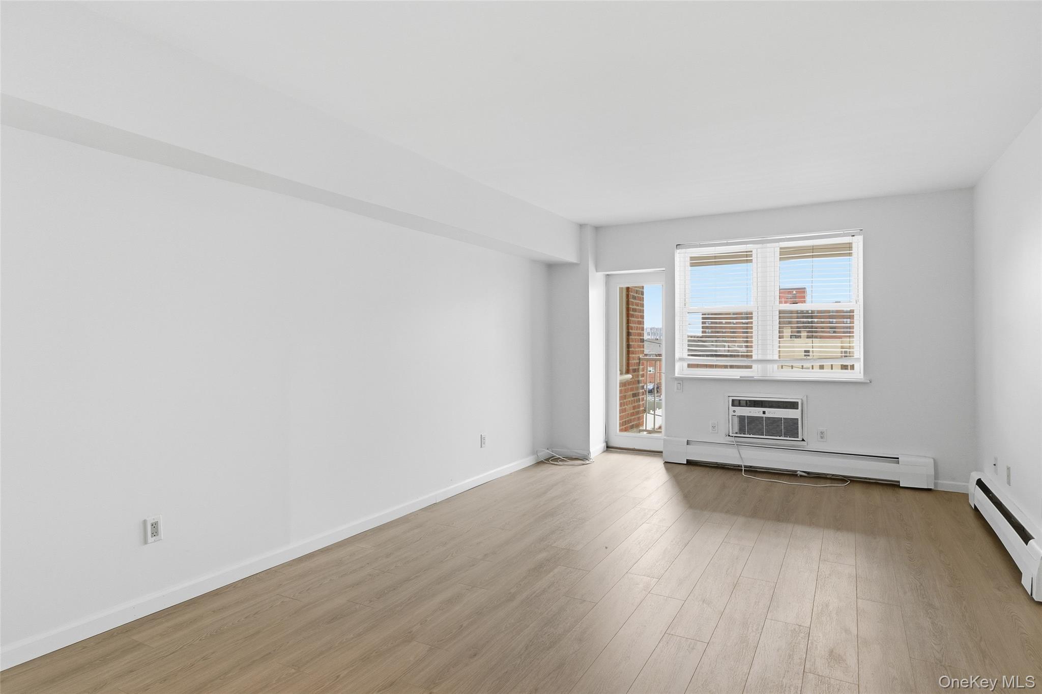 55 Monroe Boulevard, Unit 2L Long Beach, NY 11561 - Photo 15 of 25 an empty room with wooden floor and windows