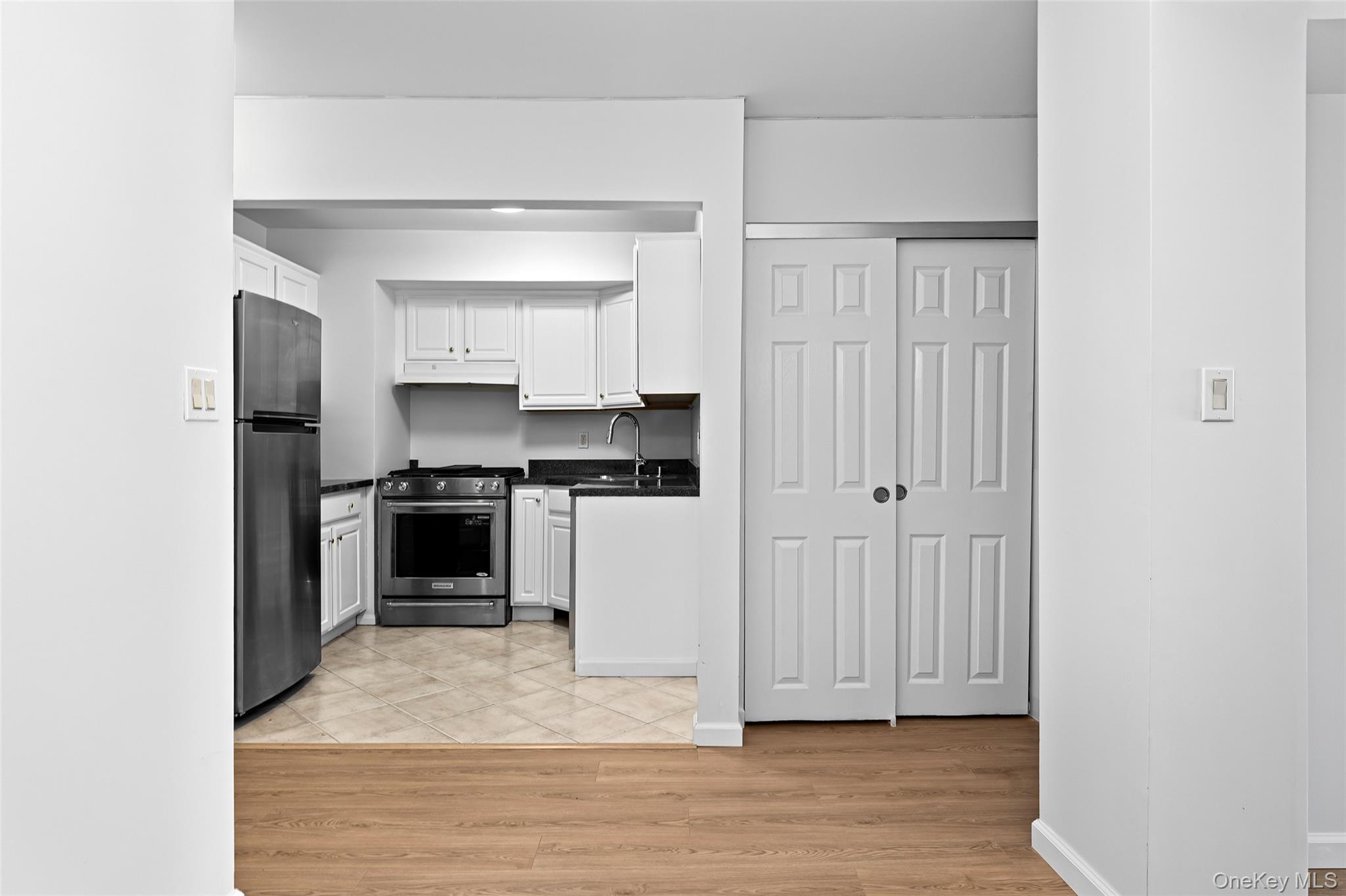 55 Monroe Boulevard, Unit 2L Long Beach, NY 11561 - Photo 16 of 25 a kitchen with cabinets and wooden floor