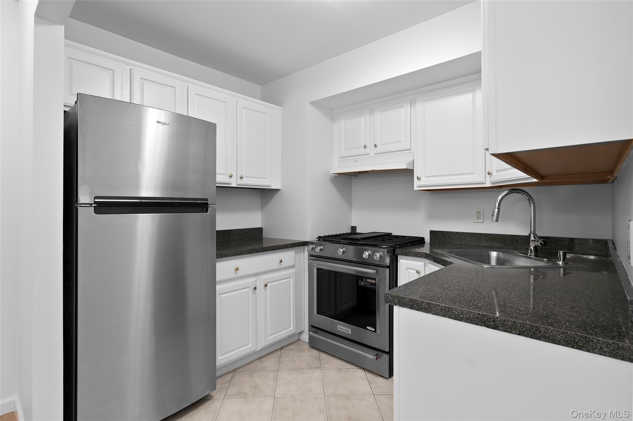 55 Monroe Boulevard, Unit 2L Long Beach, NY 11561 - Photo 3 of 25 a kitchen with a refrigerator stove and sink