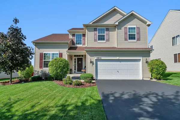 a front view of a house with a yard and garage