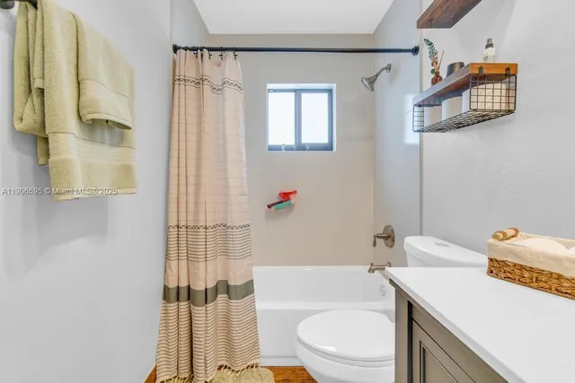 a bathroom with a sink toilet vanity and shower