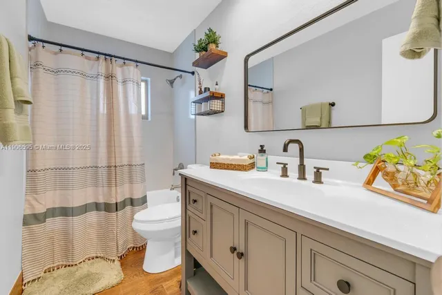 a bathroom with a sink a toilet and shower curtain
