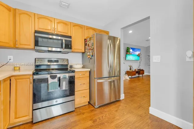 a kitchen with a refrigerator and a stove top oven