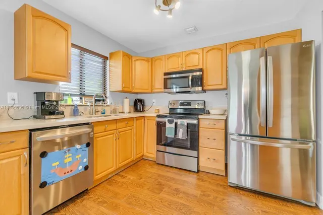 a kitchen with stainless steel appliances a stove sink and microwave