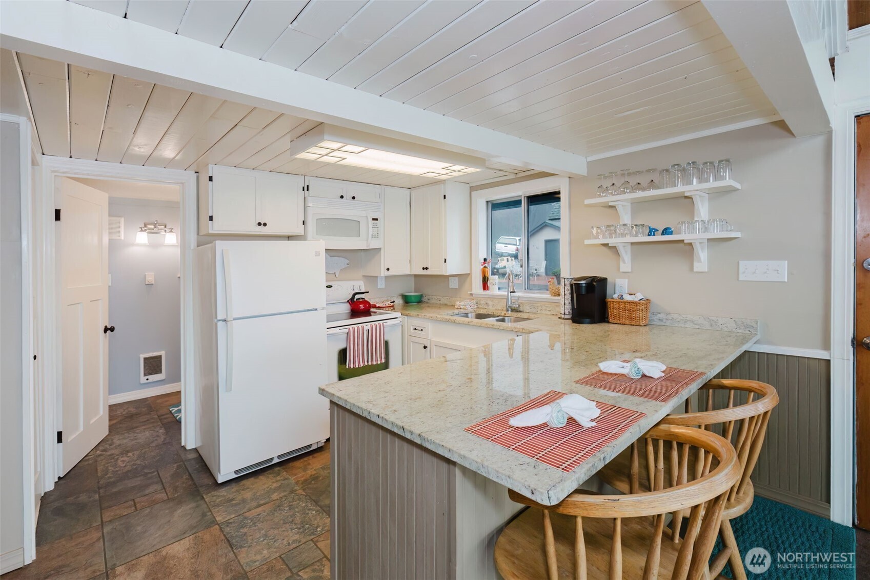10271 Northeast North Shore Road Belfair, WA 98528 - Photo 18 of 38 a open kitchen with stainless steel appliances granite countertop a dining table chairs refrigerator and sink