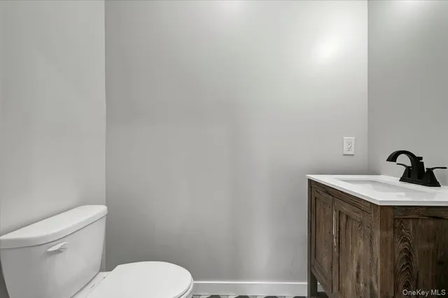 a bathroom with a granite countertop toilet and sink