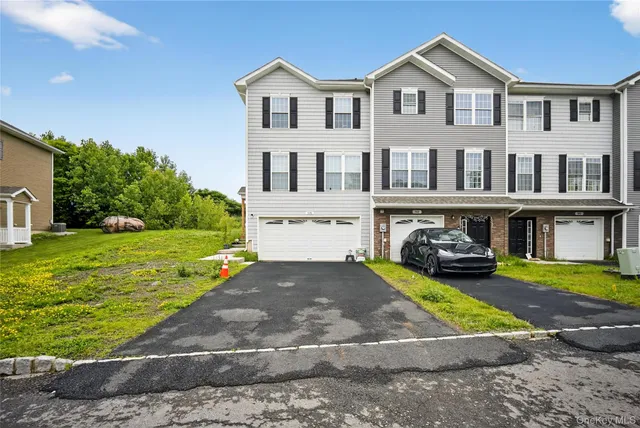 a view of a white house with a big yard and large trees