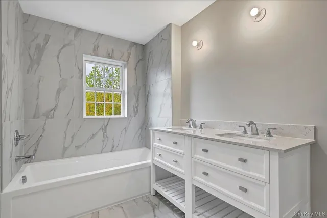 a bathroom with a tub sink and mirror