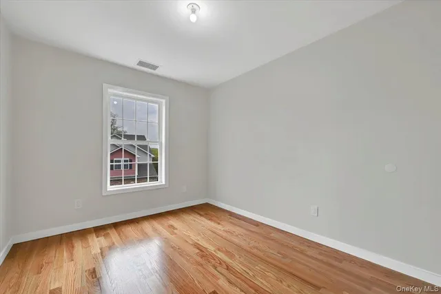 an empty room with wooden floor and a window