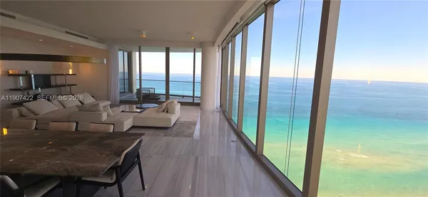 a living room with furniture and a floor to ceiling window