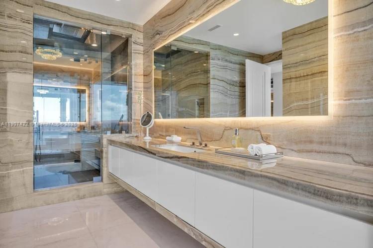 17901 Collins Avenue, Unit 2604 Sunny Isles Beach, FL 33160 - Photo 24 of 28 a bathroom with a granite countertop sink and a mirror