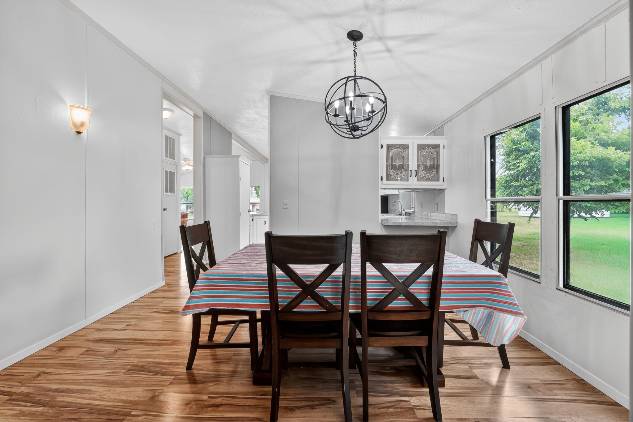 1192 County Road 225 Bluffton, TX 78607 - Photo 12 of 38 Dining space featuring wood-finish flooring, a contemporary spherical chandelier, and multiple windows