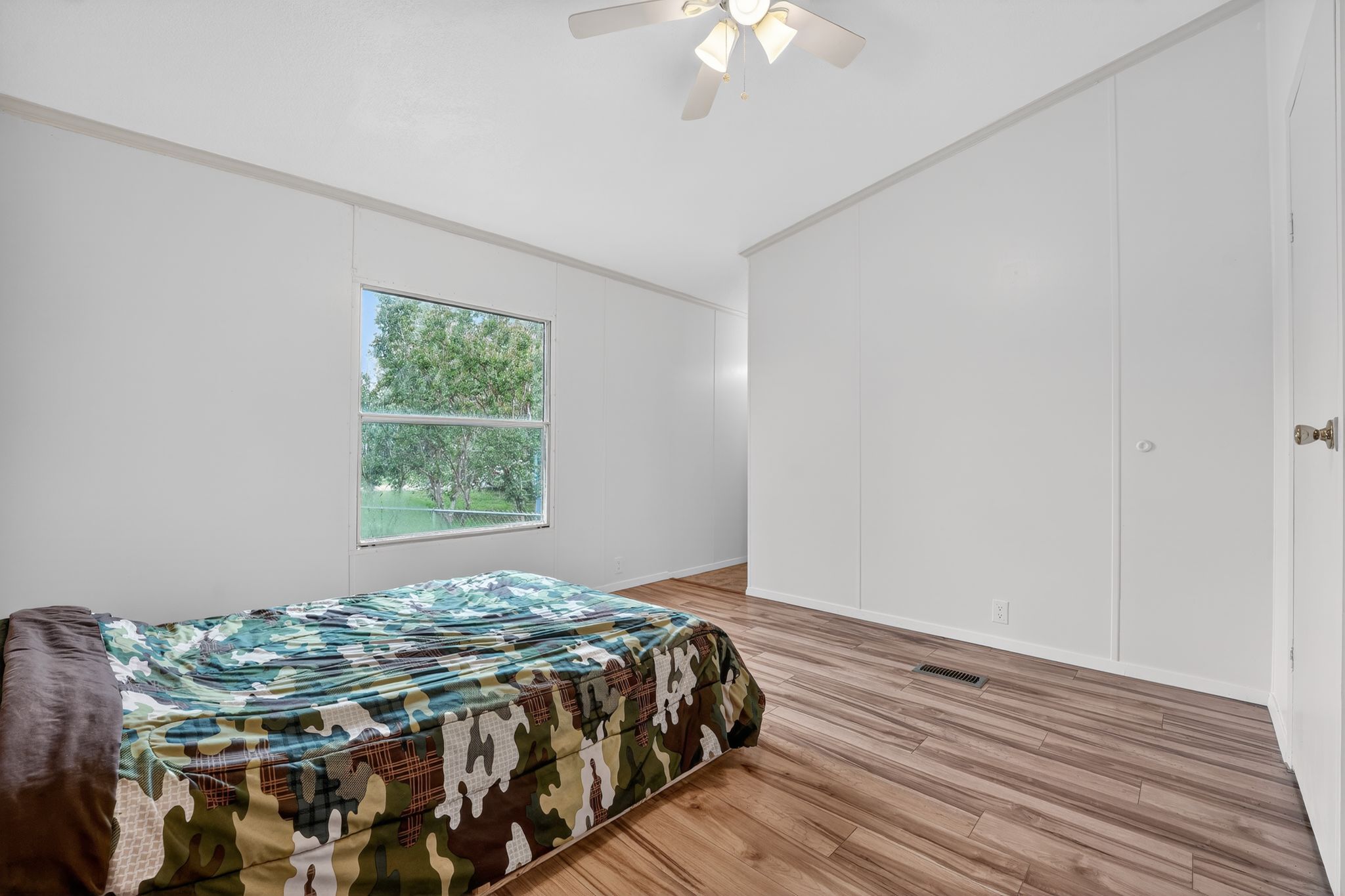 1192 County Road 225 Bluffton, TX 78607 - Photo 17 of 38 Spacious room with wood-finish flooring, a white ceiling fan, and white paneled walls