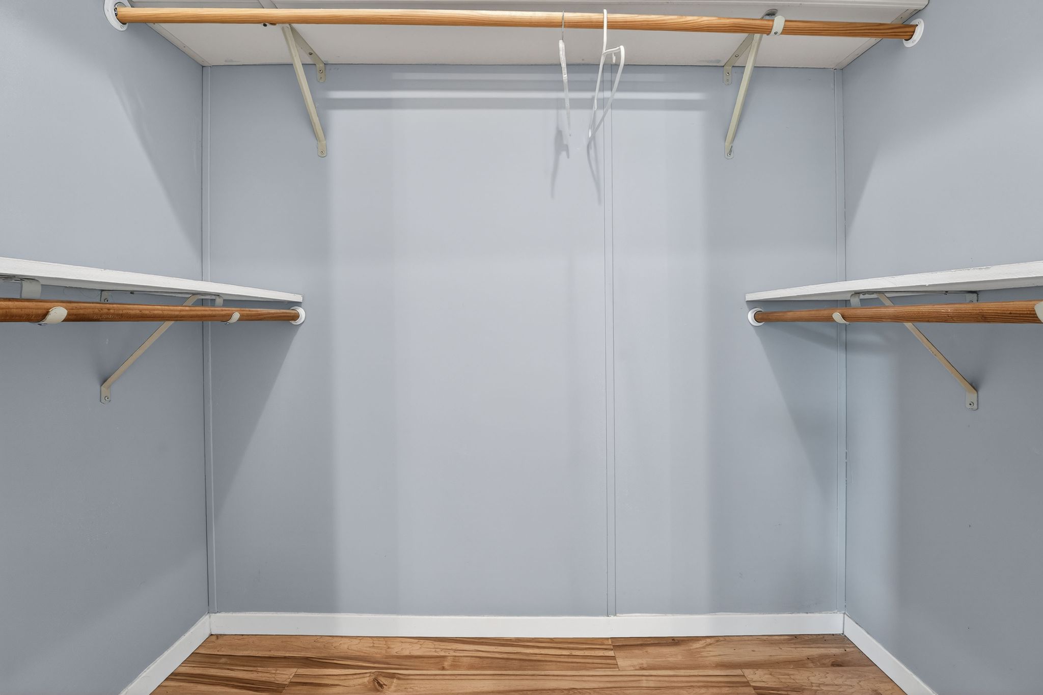 1192 County Road 225 Bluffton, TX 78607 - Photo 29 of 38 Spacious closet featuring light blue walls, wood-finish flooring, white trim, and multiple shelving and hanging rods