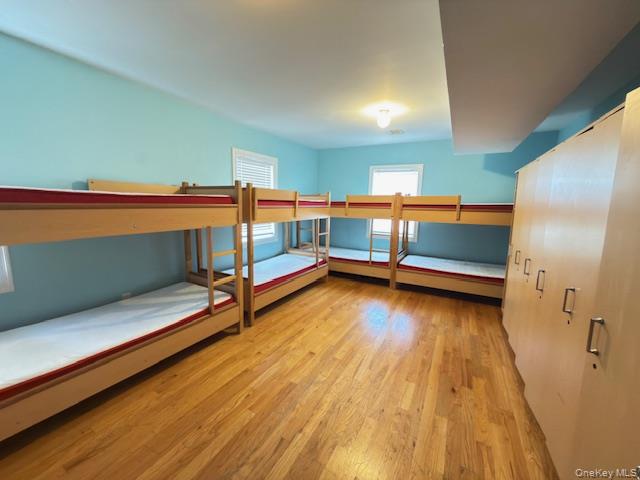 48 Church Street Patchogue, NY 11772 - Photo 6 of 19 a bedroom with wooden floor and windows