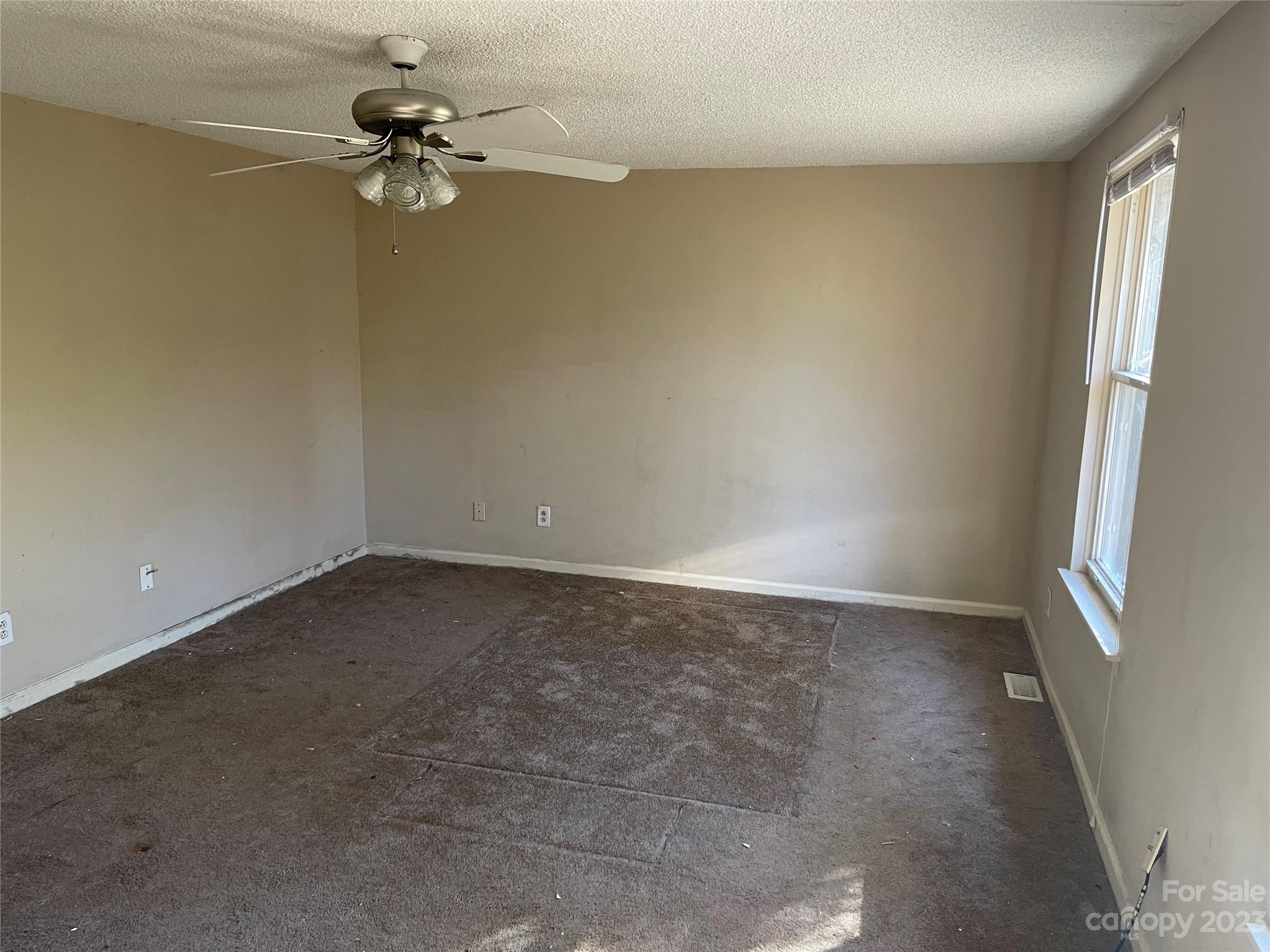 2940 Rural Hill Court Matthews, NC 28105 - Photo 21 of 24 an empty room with a chandelier fan and windows