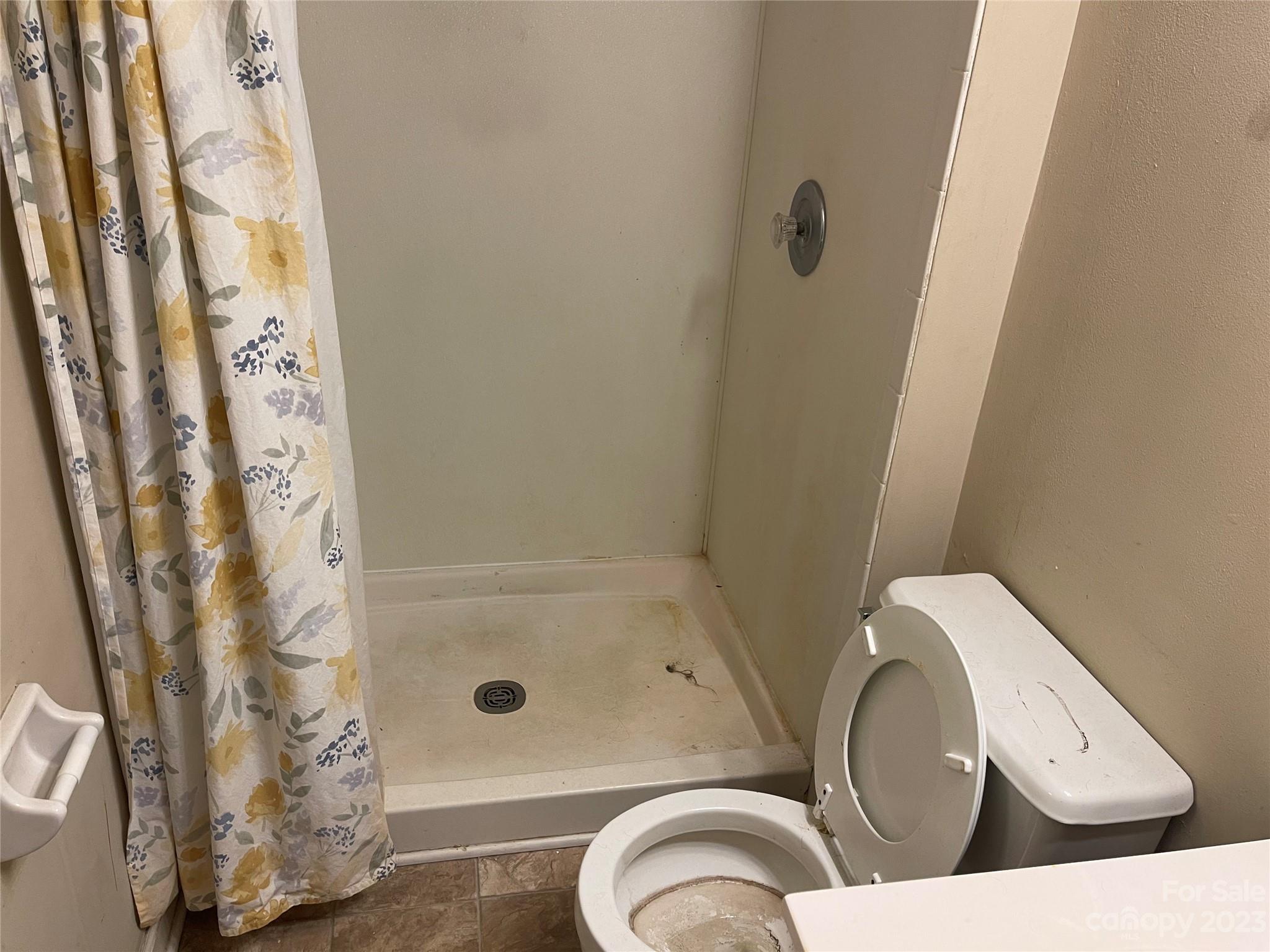 2940 Rural Hill Court Matthews, NC 28105 - Photo 22 of 24 a bathroom with a toilet and a shower curtain