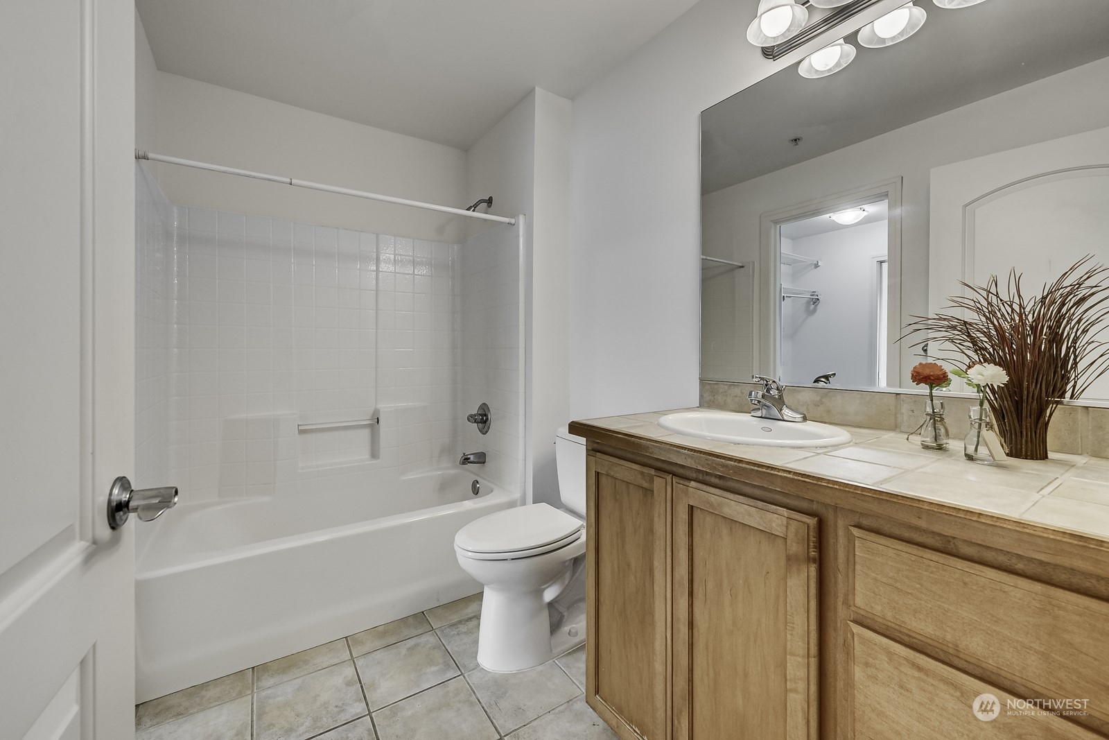 3121 West Government Way, Unit 405 Seattle, WA 98199 - Photo 18 of 29 a bathroom with a granite countertop sink a toilet mirror and shower