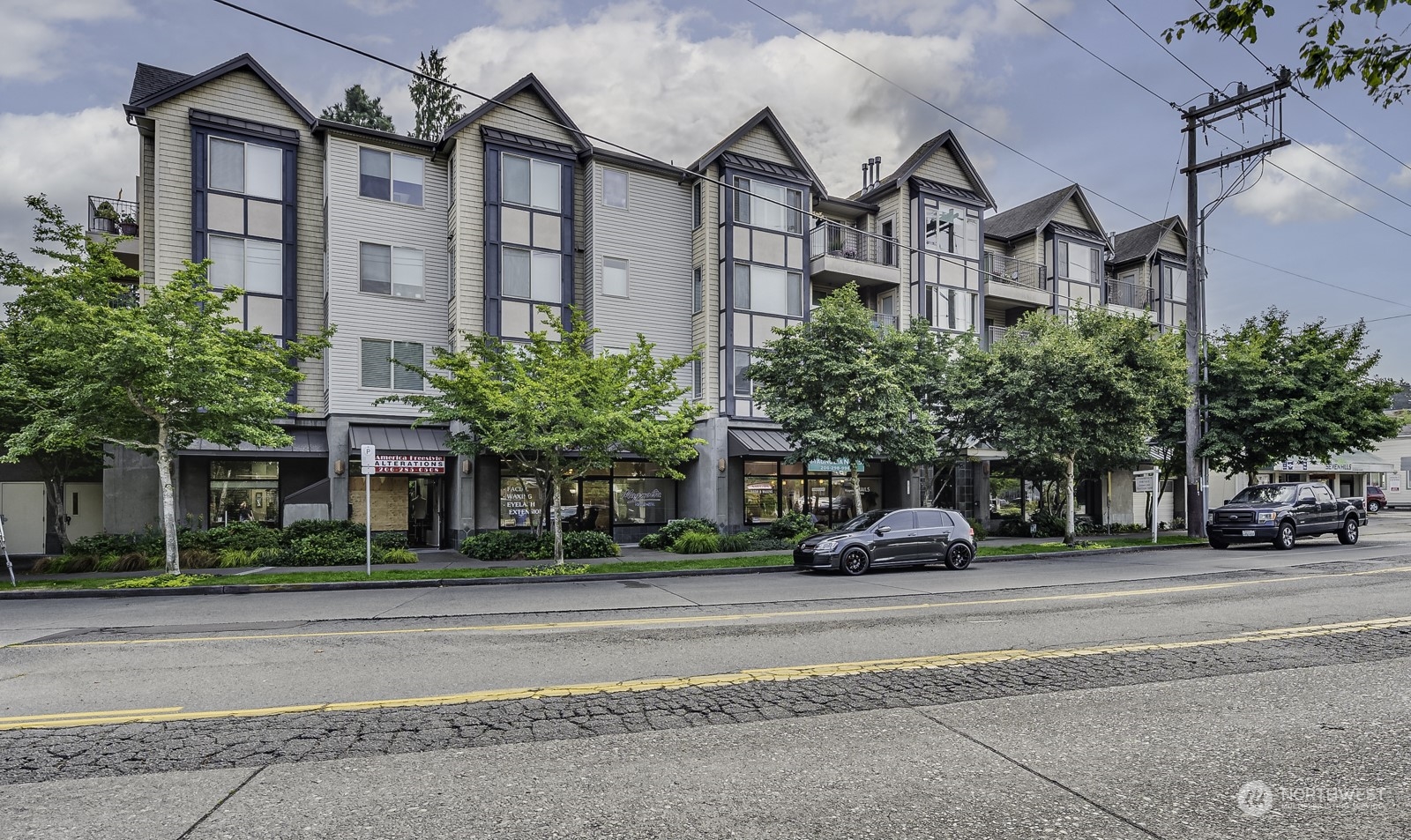 3121 West Government Way, Unit 405 Seattle, WA 98199 - Photo 2 of 29 a front view of residential houses and street