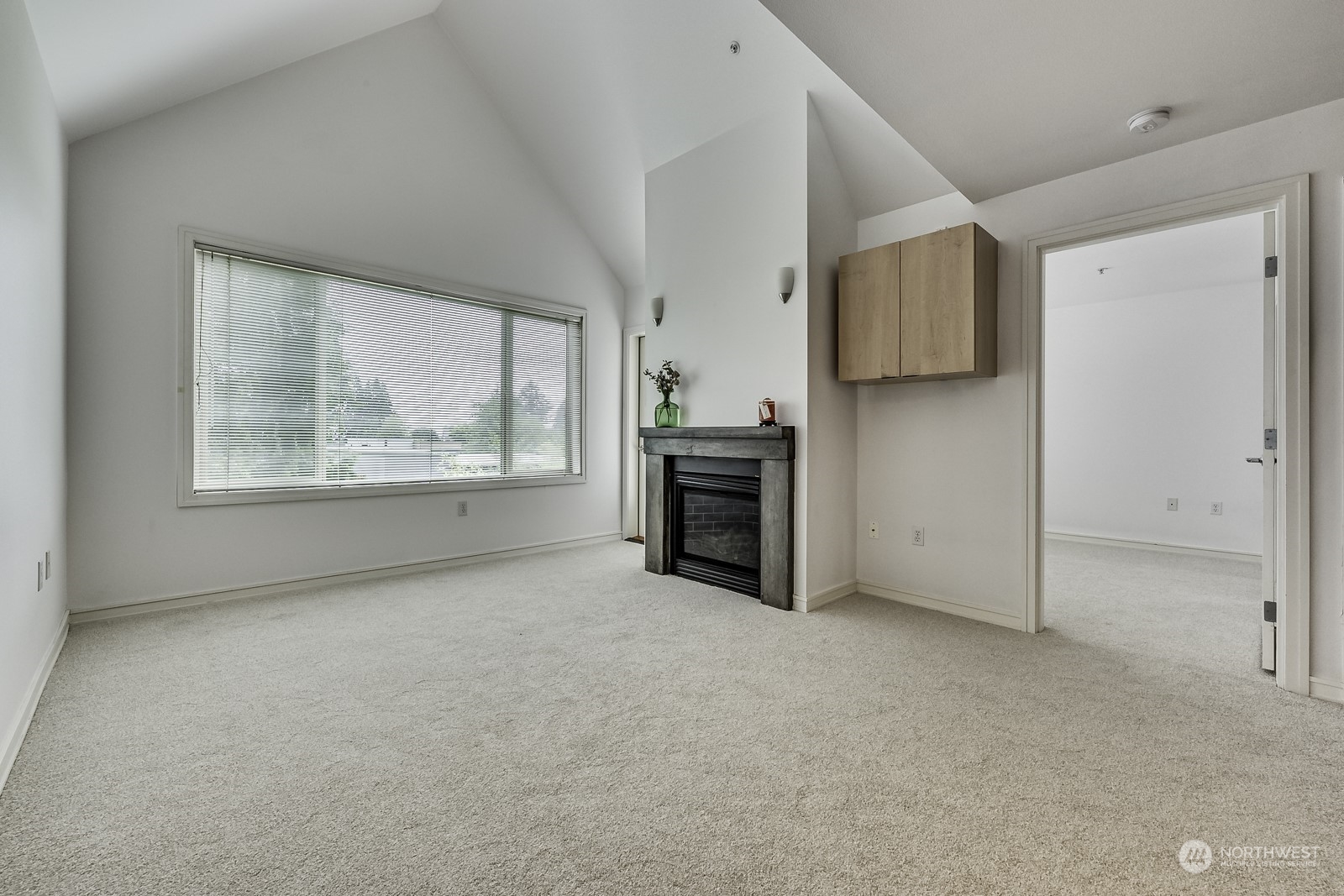 3121 West Government Way, Unit 405 Seattle, WA 98199 - Photo 6 of 29 an empty room with windows cabinet and fireplace