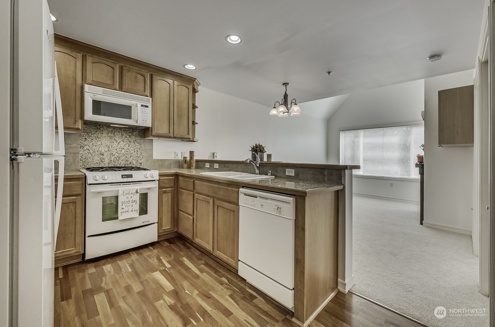 3121 West Government Way, Unit 405 Seattle, WA 98199 - Photo 10 of 29 a kitchen with stainless steel appliances granite countertop a stove a sink and a refrigerator