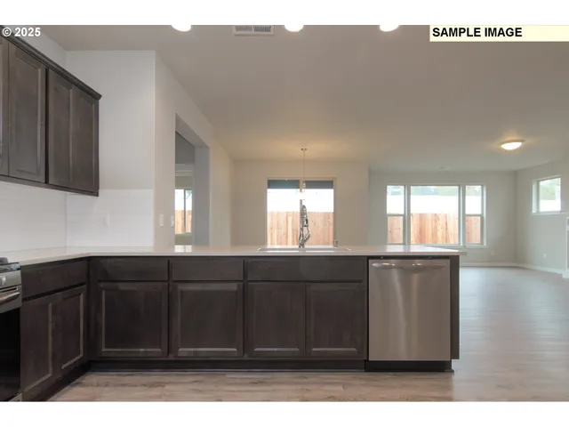 a kitchen with granite countertop a sink a window and cabinets