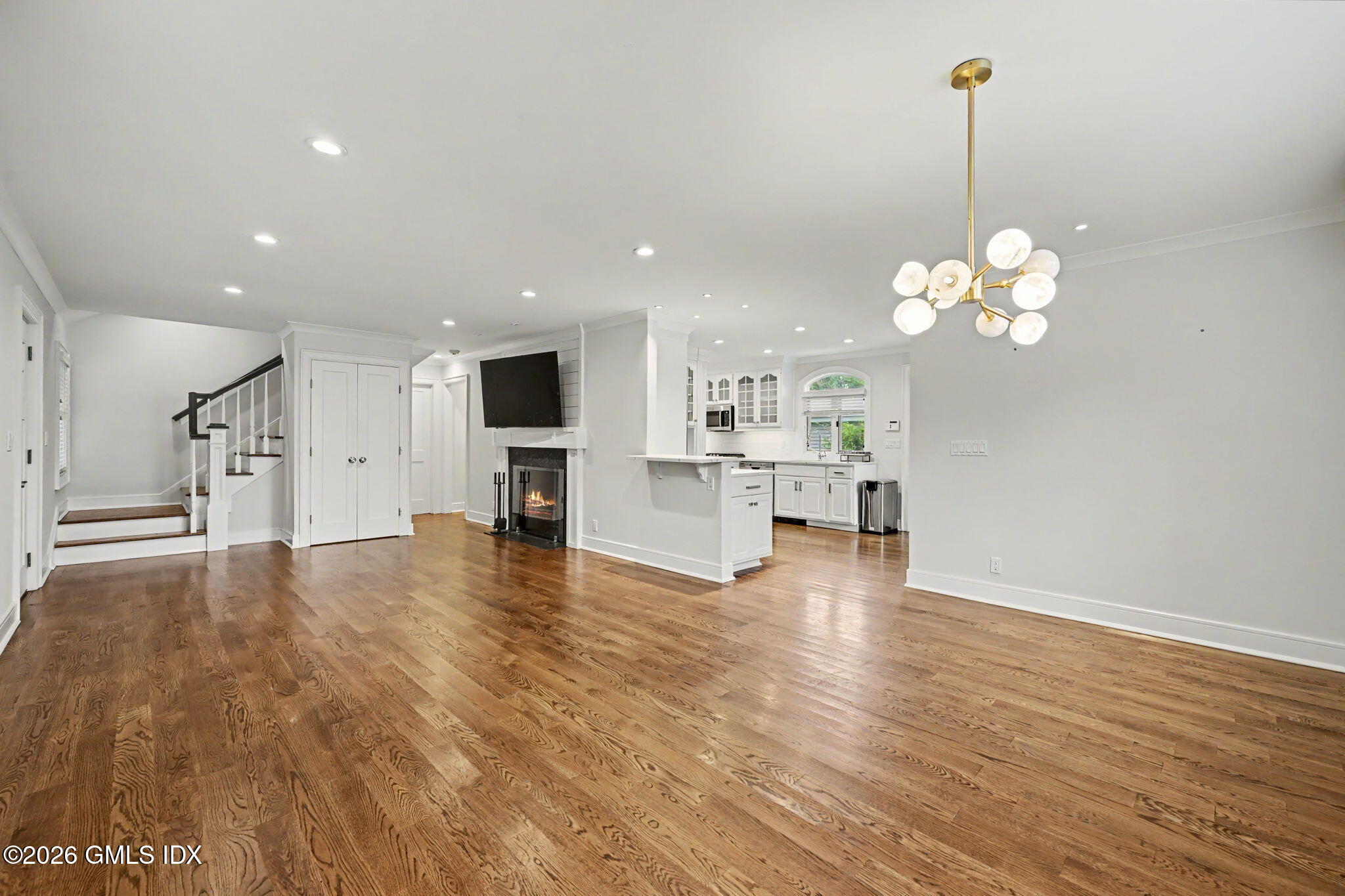 124 Shore Road Old Greenwich, CT 06870 - Photo 6 of 28 a view of a kitchen with a stove wooden cabinets and a chandelier