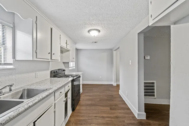 a kitchen with a sink stove and cabinets