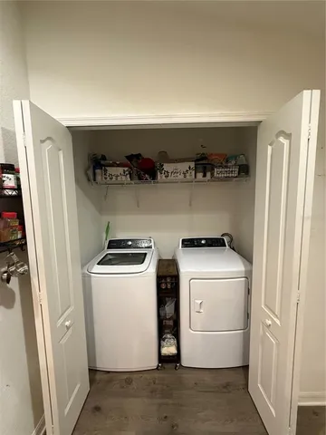 a living room with stainless steel appliances kitchen island granite countertop a refrigerator and a stove top oven with wooden floor