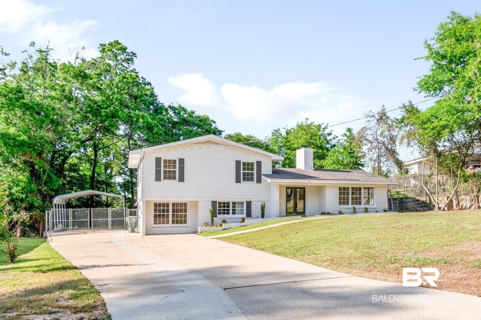 115 Pineridge Road Daphne, AL 36526 - Photo 1 of 34 Tri-level home with a front lawn, driveway, a chimney, and fence