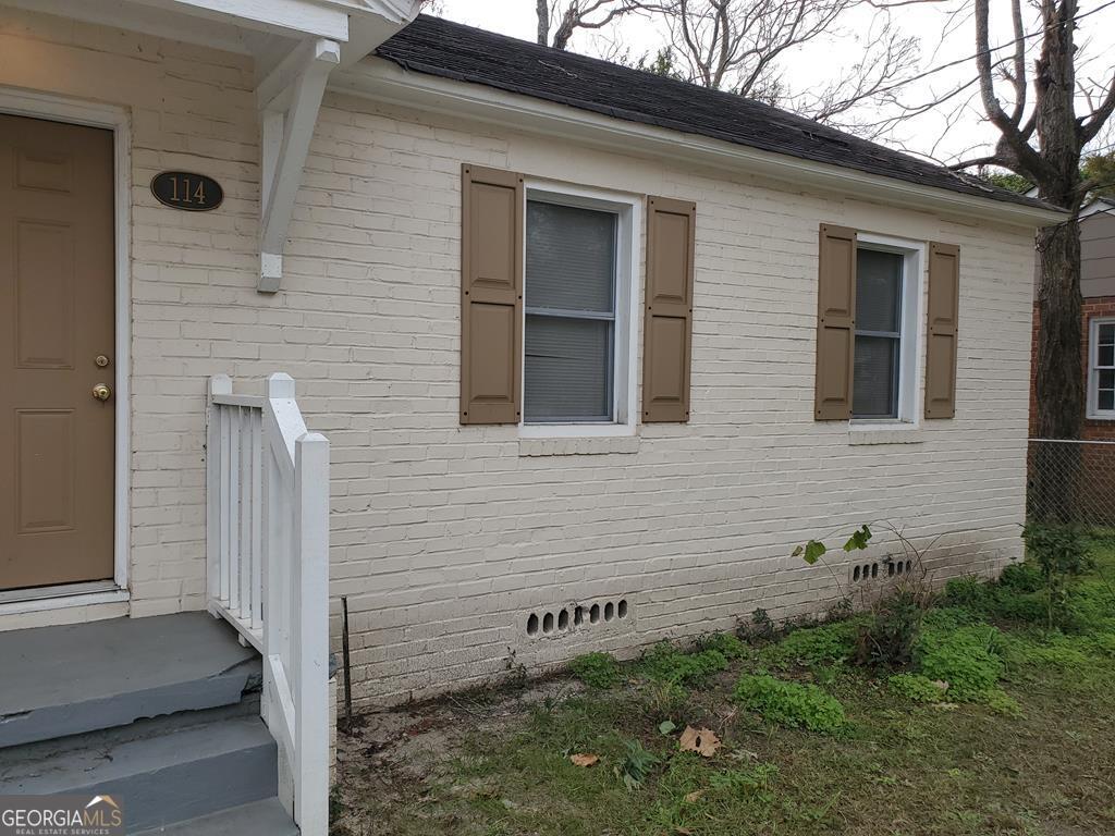 a view of a brick house with a yard