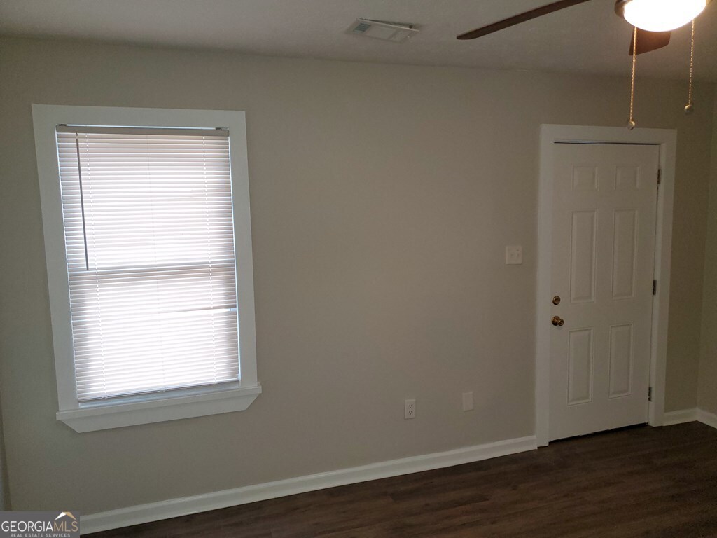 114 West Mary Street Dublin, GA 31021 - Photo 4 of 4 a view of an empty room with wooden floor and a window