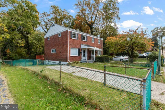 a view of house with a yard and a large tree
