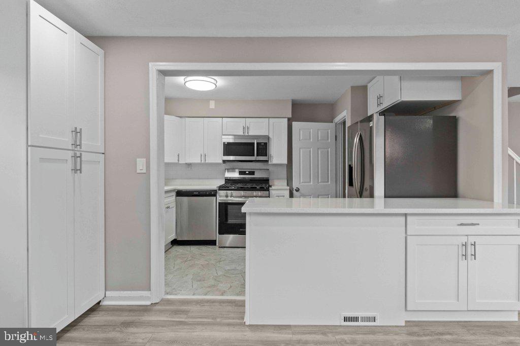 6307 Fairdel Avenue Baltimore, MD 21206 - Photo 11 of 36 a kitchen with white cabinets and stainless steel appliances