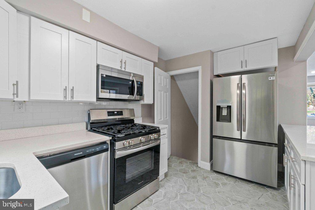 6307 Fairdel Avenue Baltimore, MD 21206 - Photo 13 of 36 a kitchen with stainless steel appliances white cabinets and a stove top oven