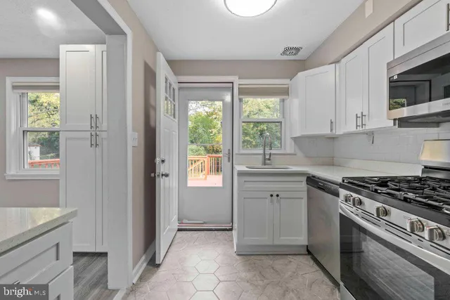 a kitchen with cabinets appliances and a window