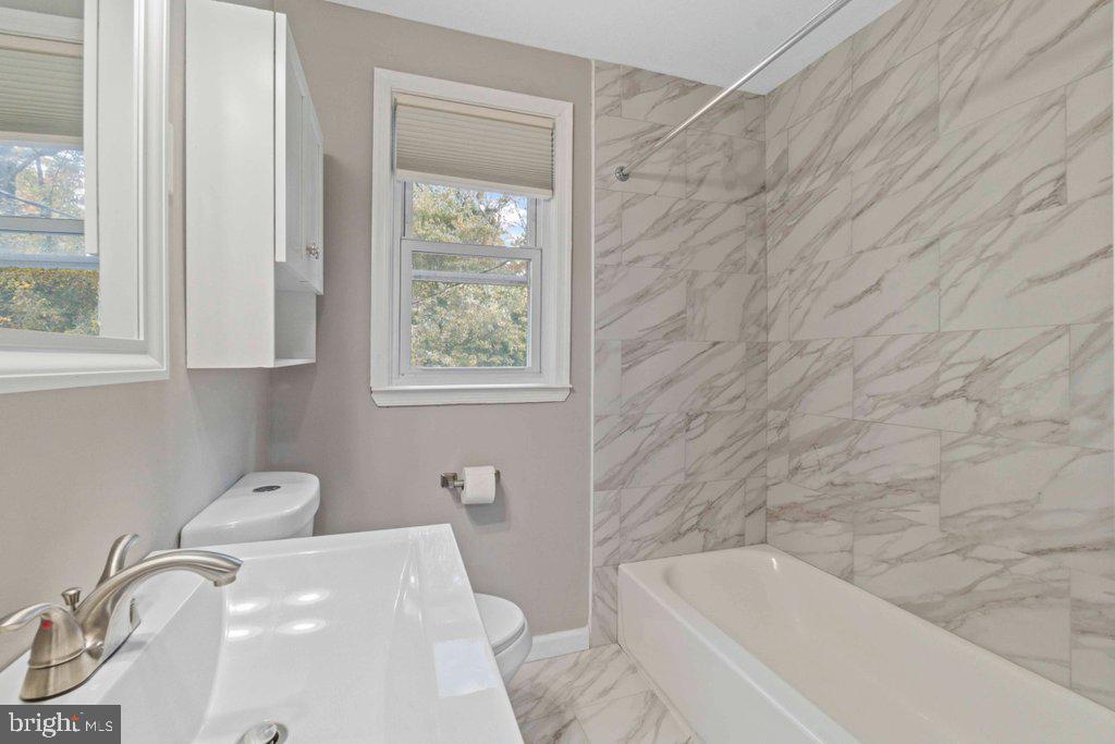 6307 Fairdel Avenue Baltimore, MD 21206 - Photo 17 of 36 a bath tub sitting next to a white sink and vanity