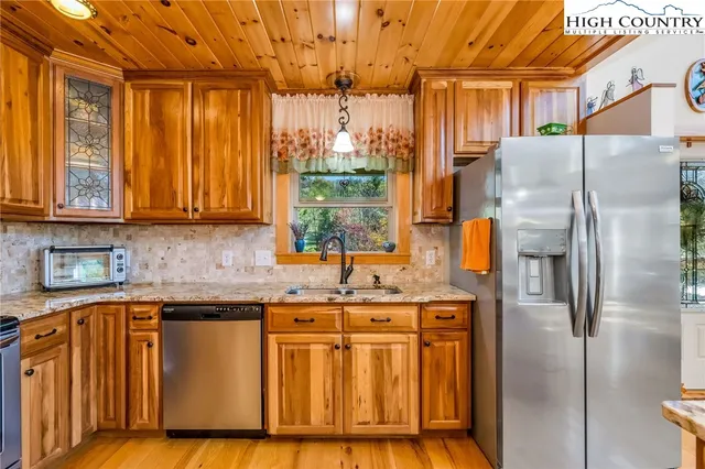 a kitchen with granite countertop cabinets stainless steel appliances and a counter space