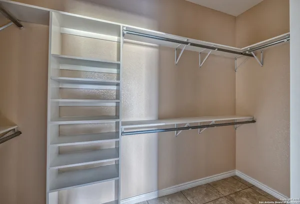 a view of walk in closet with empty racks