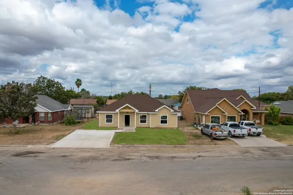 an aerial view of residential houses with outdoor space and parking