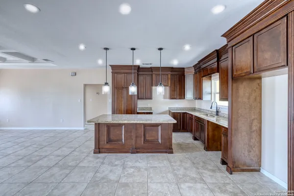 a large kitchen with stainless steel appliances granite countertop a stove a sink and a refrigerator