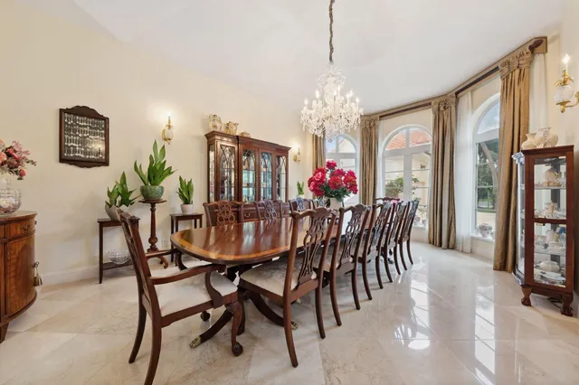 a view of a dining room with furniture a chandelier and window