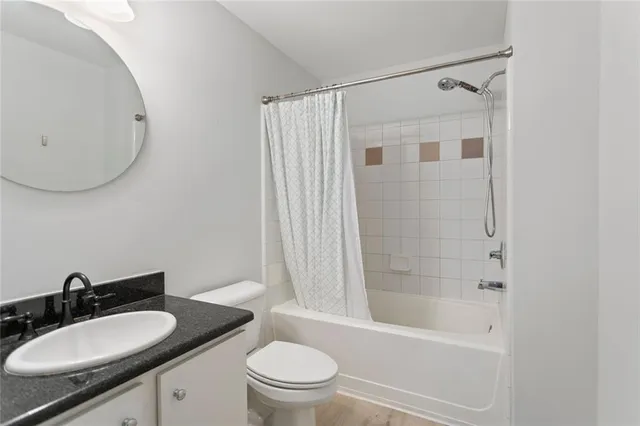 a bathroom with a granite countertop sink toilet a mirror and shower