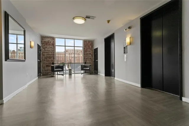 an empty room with wooden floor and windows