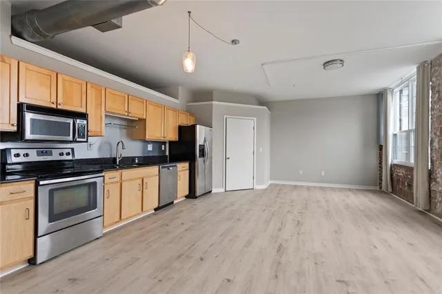 a kitchen with stainless steel appliances granite countertop a stove a sink and a microwave