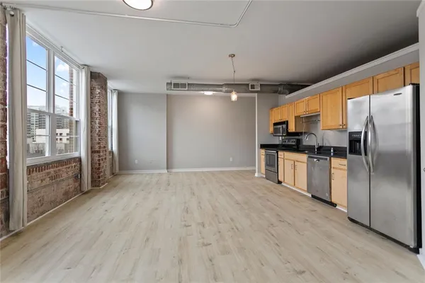 a view of a kitchen with a sink refrigerator and wooden floor